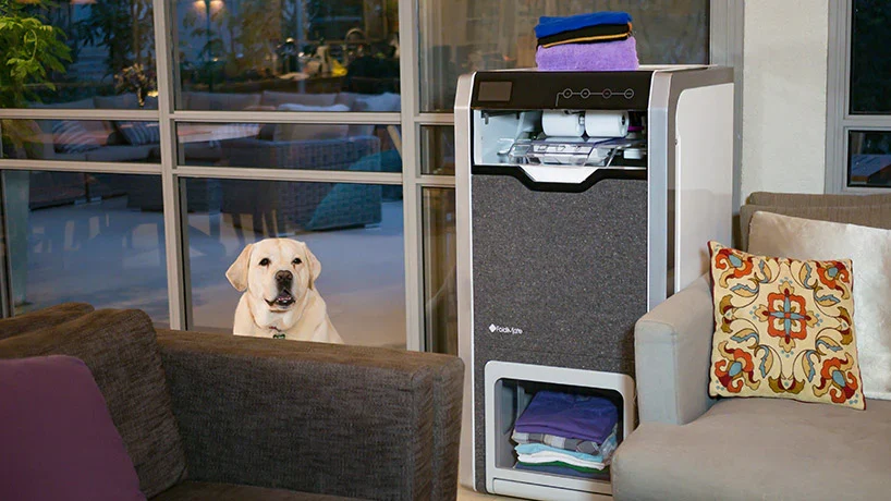 Machine Foldimate installée dans un intérieur, avec du linge plié dans son compartiment inférieur