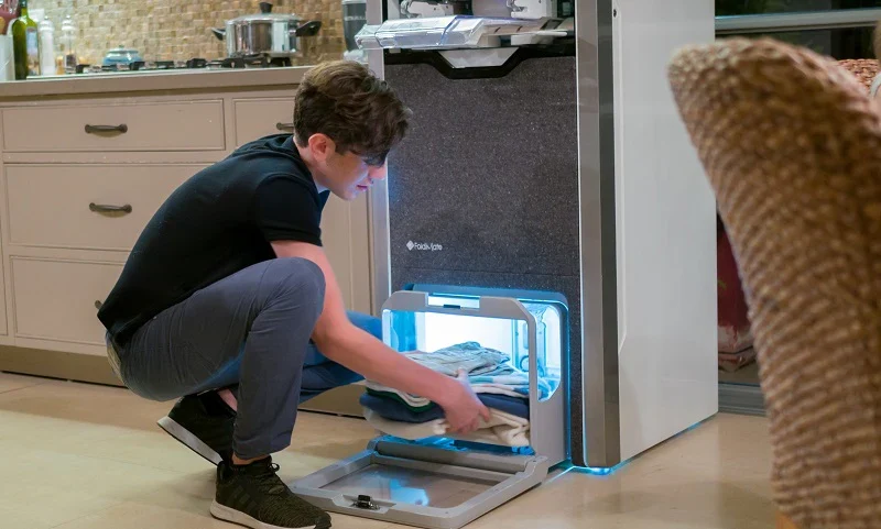 Récupération d’une pile de vêtements pliés dans le compartiment inférieur de Foldimate